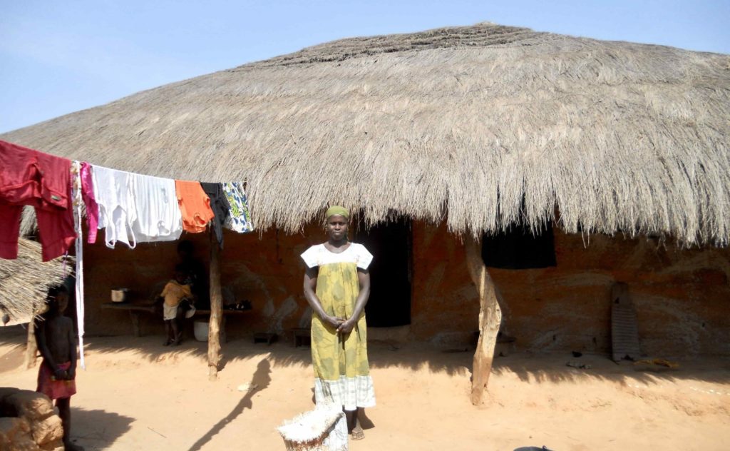 woman standing in front of her hut in Guinea-Bissau