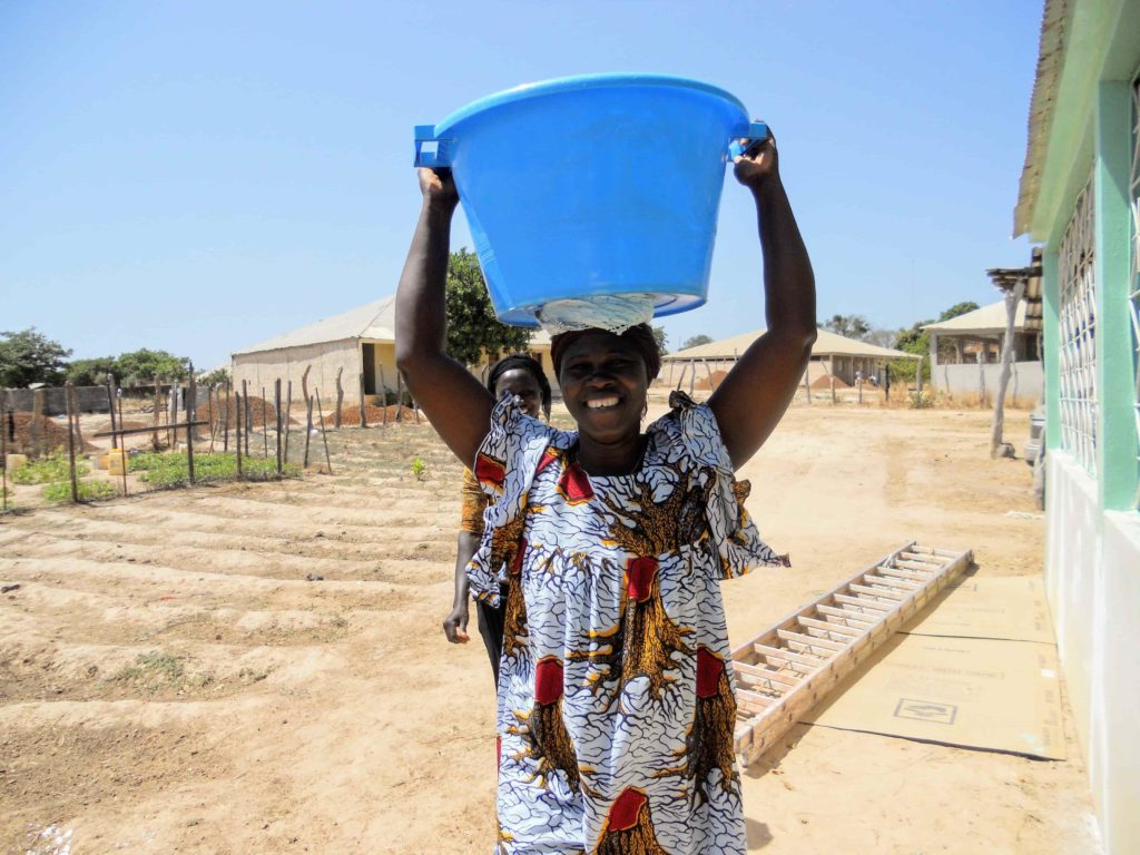 Guinean woman carrying water on her head