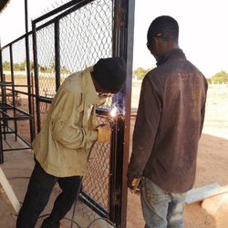Welders in West Africa welding a gate