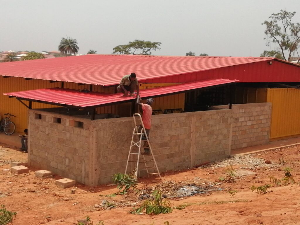 Welding students at the WAVS vocational Schools in Guinea-Bissau put a new roof over the bathrooms on the temporary welding workshop.