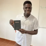 Mario, an English teacher, shows off one of the new Bibles.