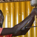 Welding graduate Augusto from Guinea-Bissau adjusts a drill press in a workshop.